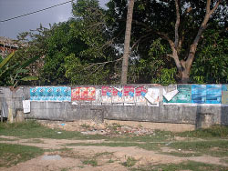 cigarette posters covering a fence in cambodia